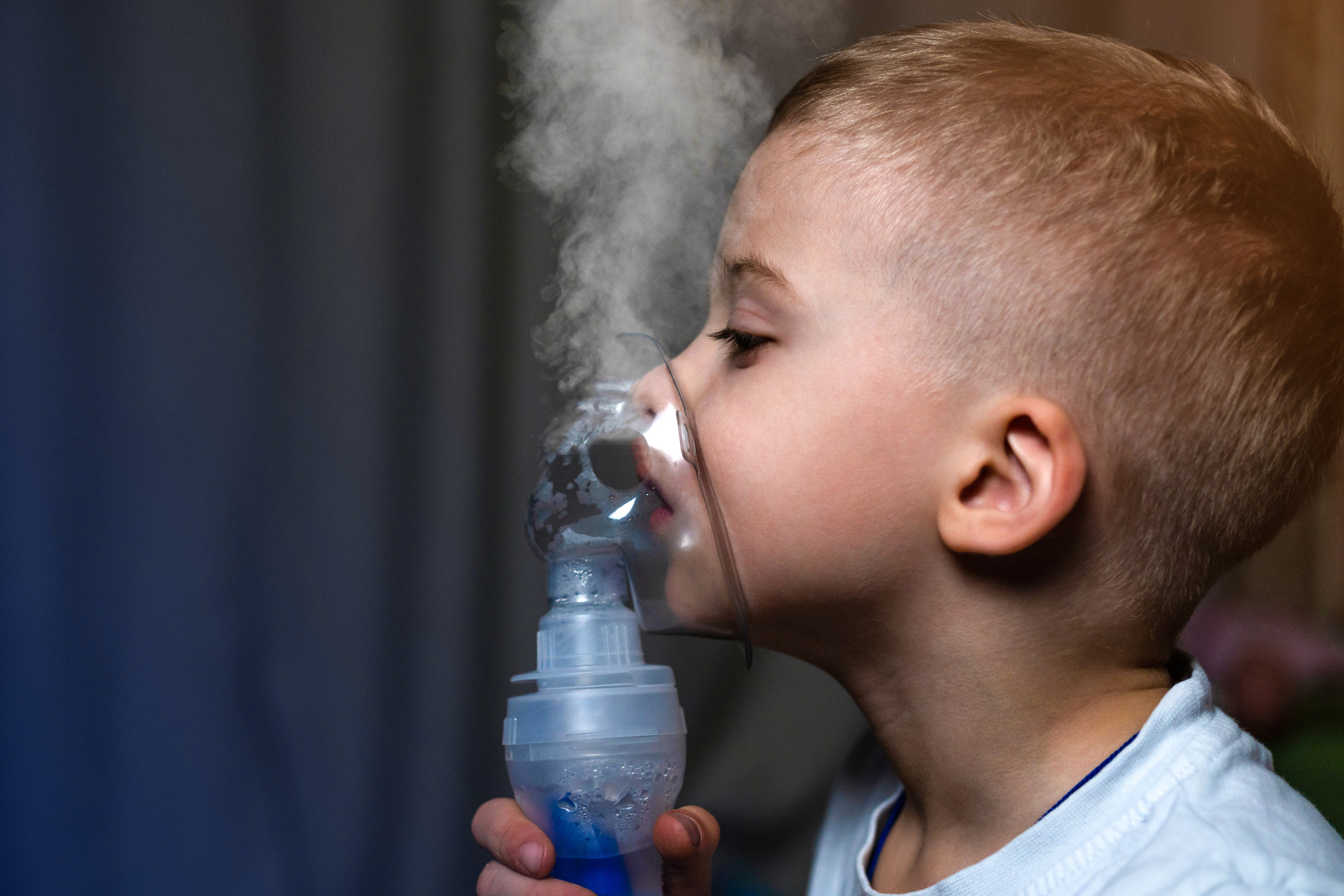Inhalation child infant under five year. Boy making inhalation with nebulizer at home